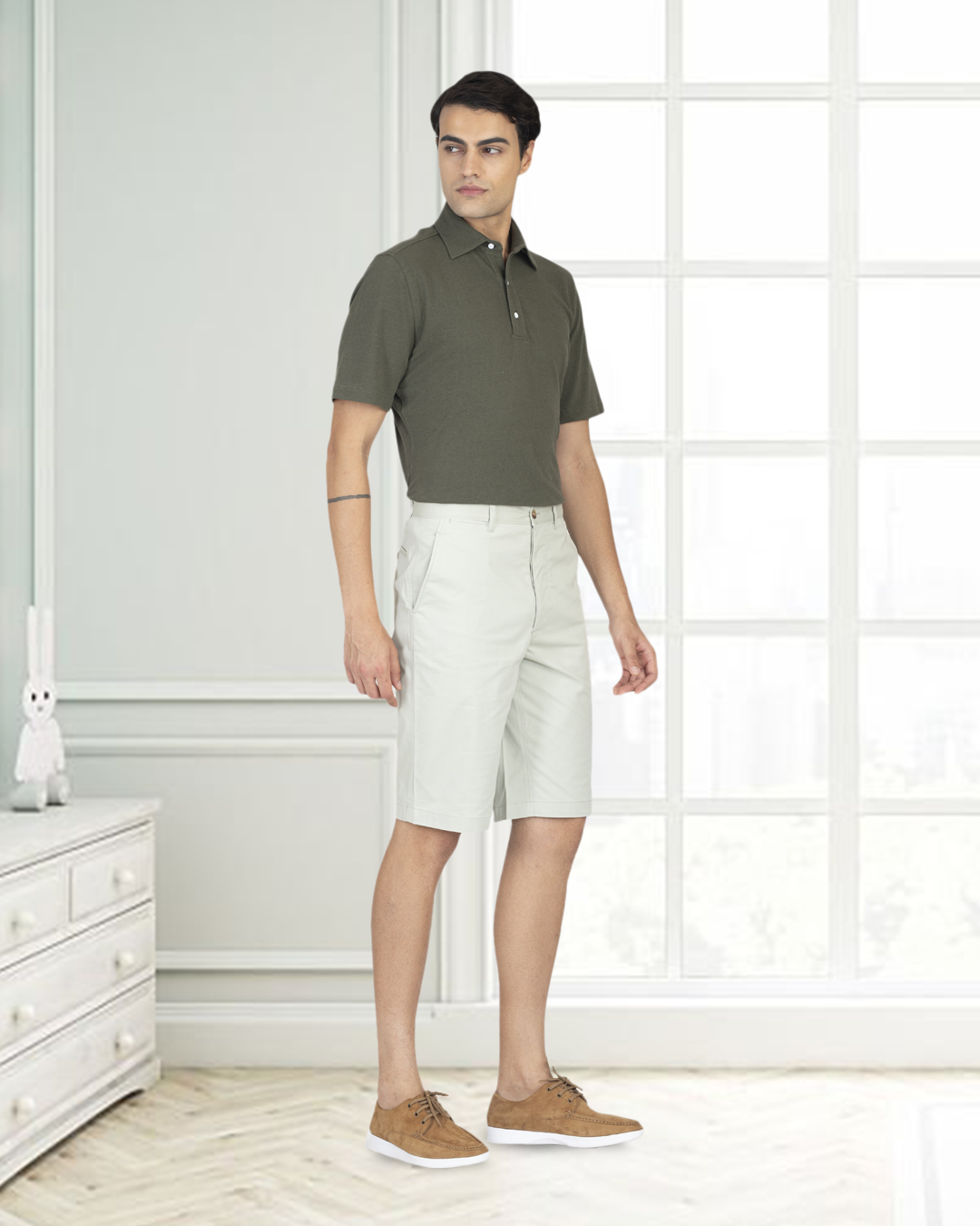 Model wearing custom Genoa shorts for men by Luxire in pale green wearing tan shoes