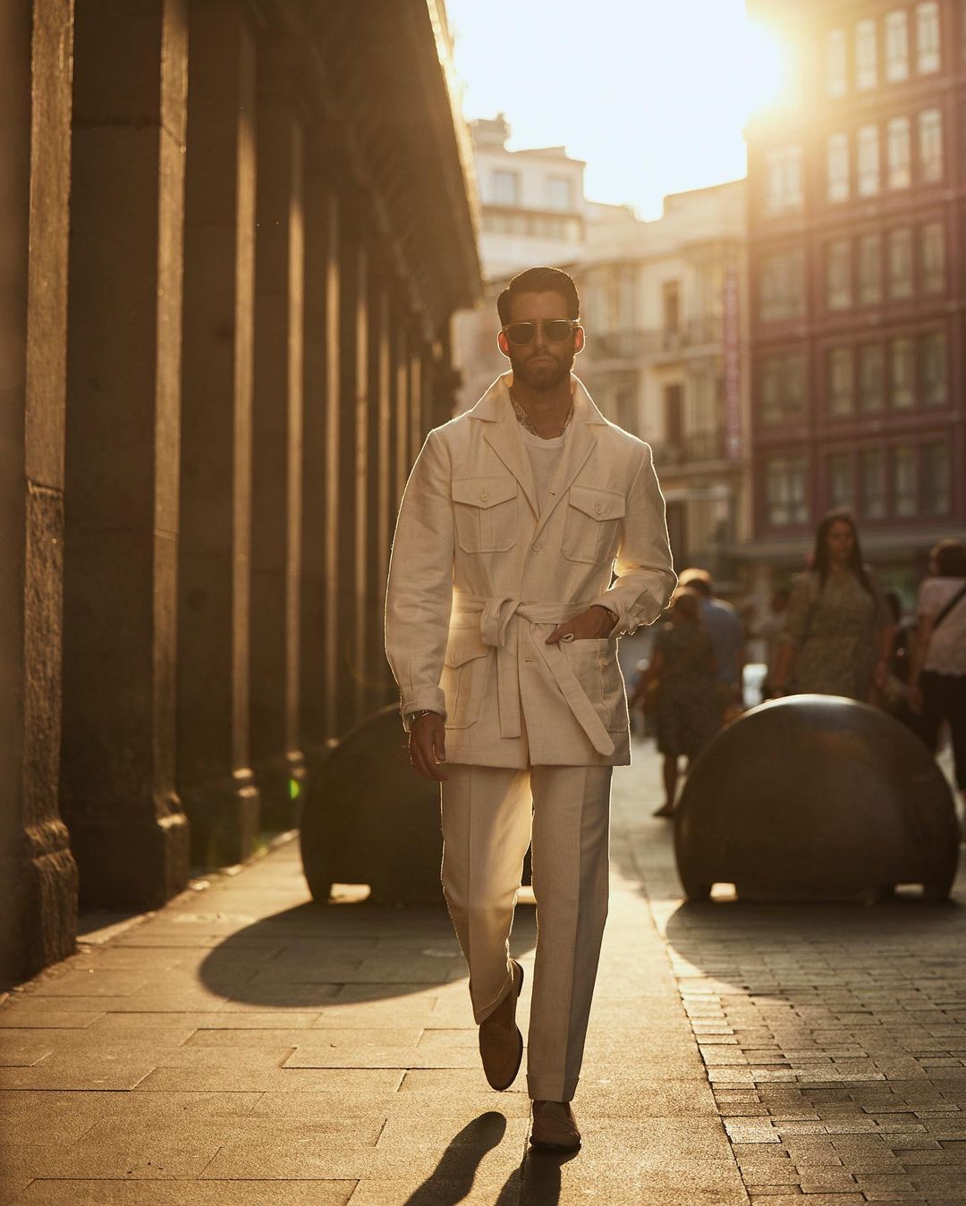 Model outside walking wearing custom linen Gurkha pants for men by Luxire in off white