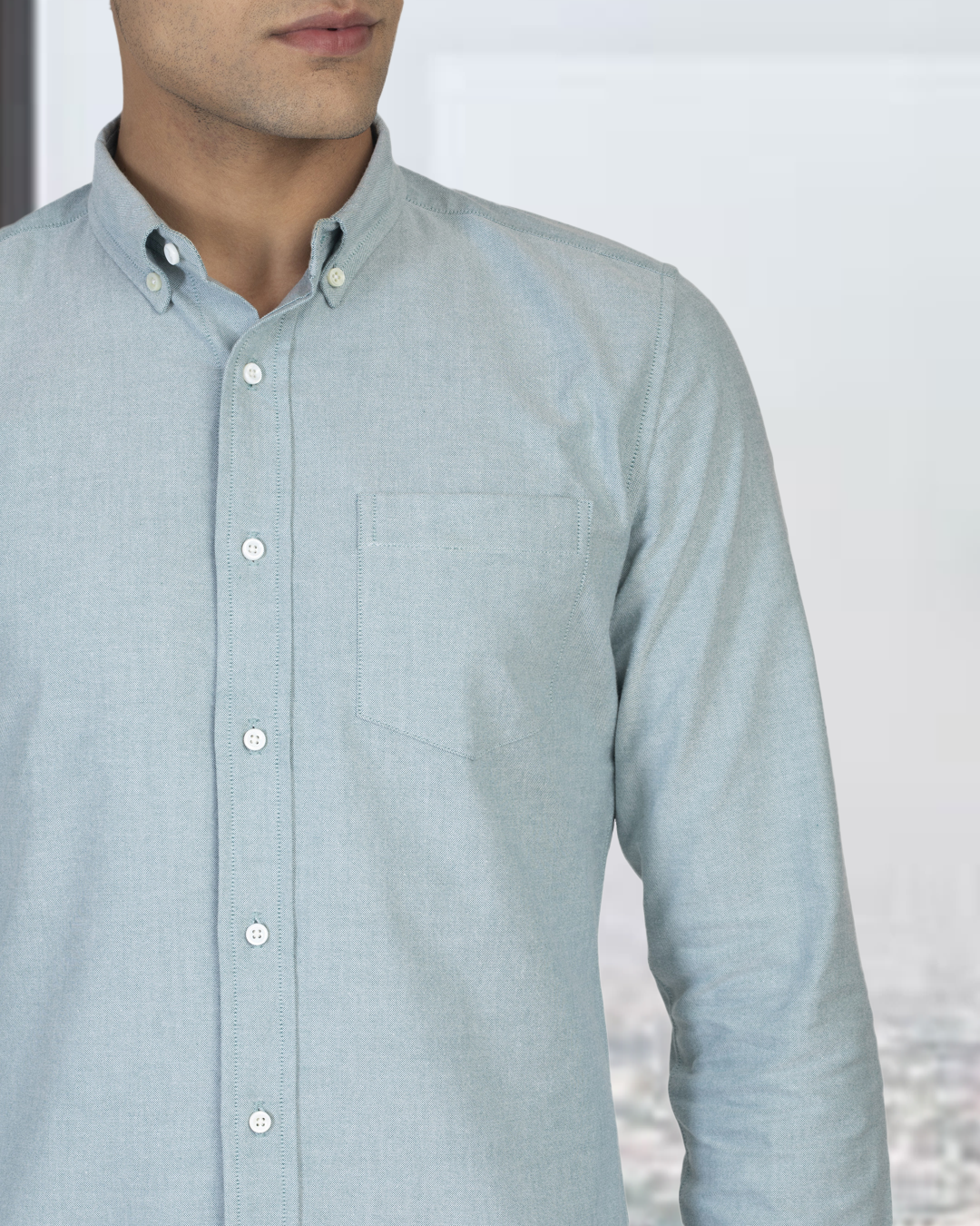 Close up of model wearing the custom oxford shirt for men by Luxire in mint green hand at side