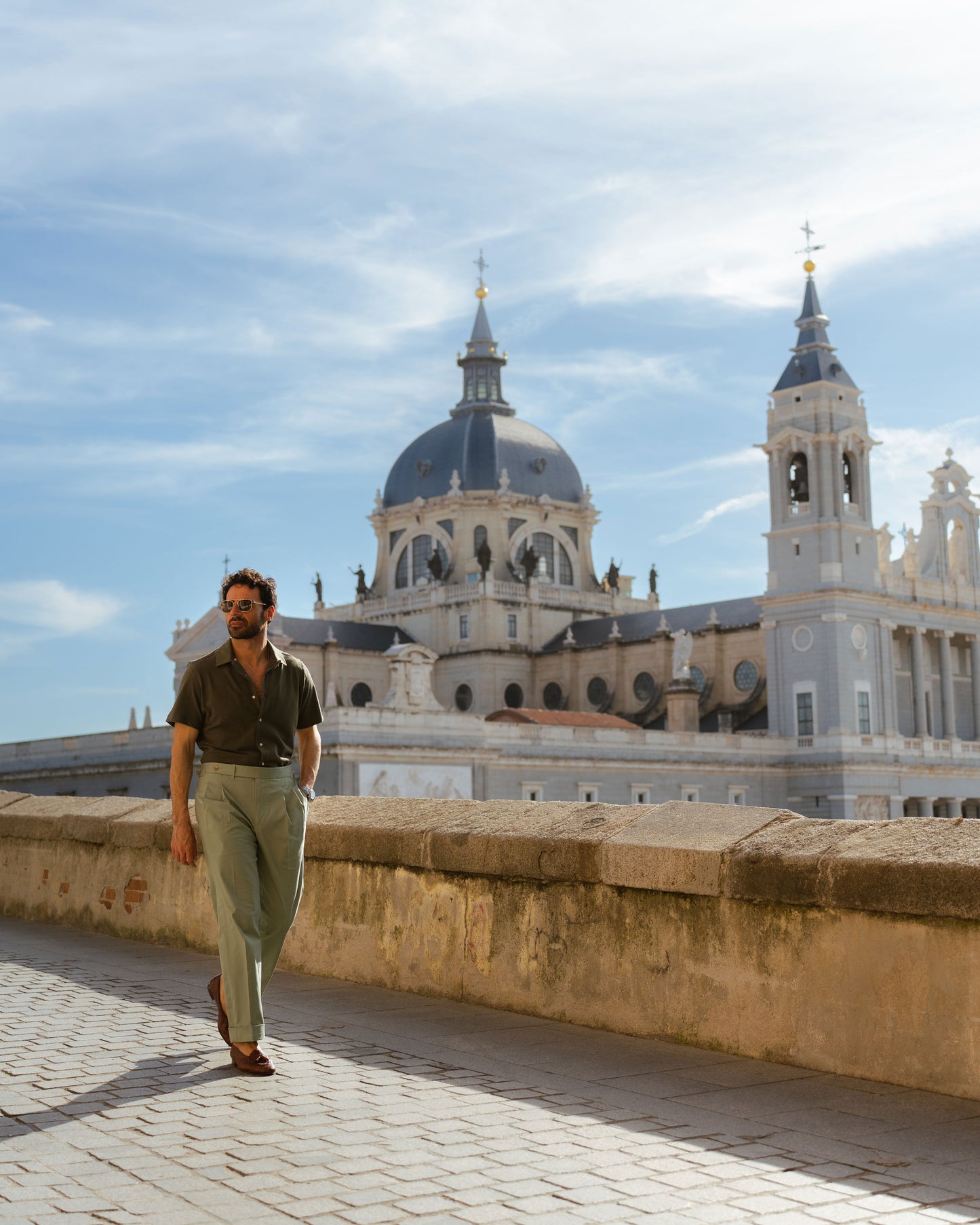 Model outside wearing mens custom polo cotton camp shirt by Luxire in olive green hand in pocket 9