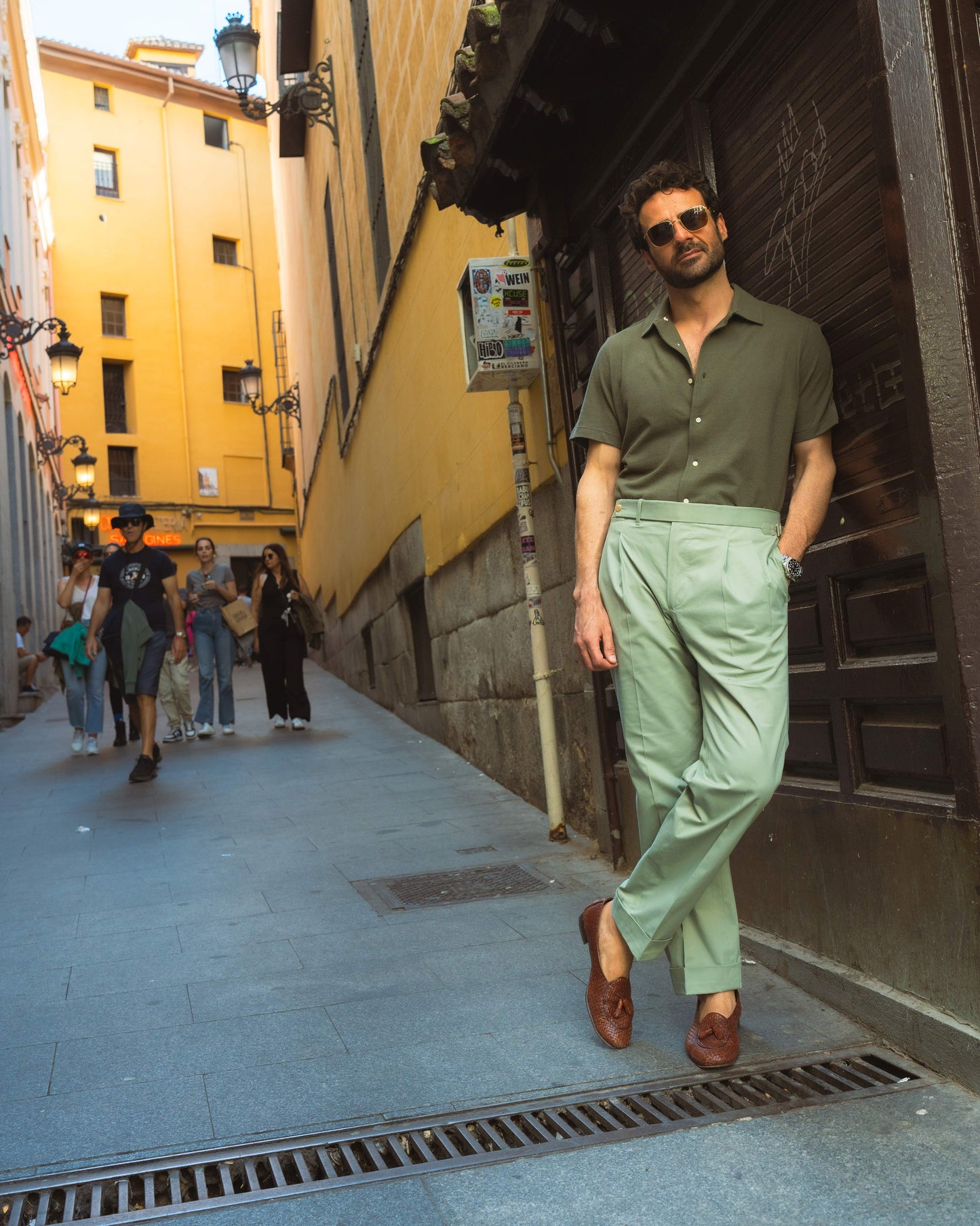 Model outside wearing the custom oxford polo shirt for men by Luxire in olive green hand in pocket 3