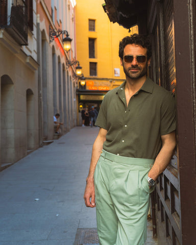 Model outside wearing the custom oxford polo shirt for men by Luxire in olive green
