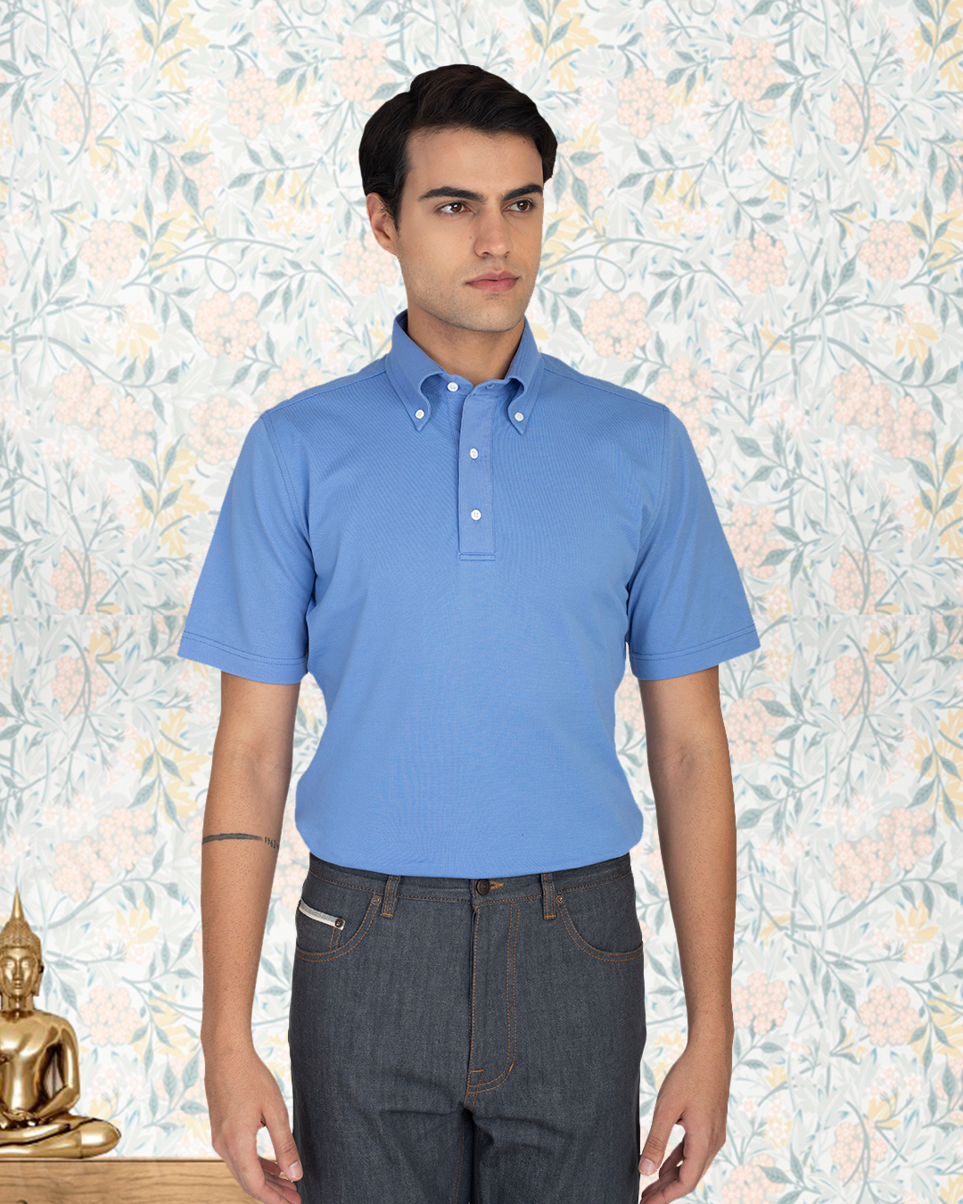 Close up view of model wearing the custom oxford polo shirt for men by Luxire in soft blue 2