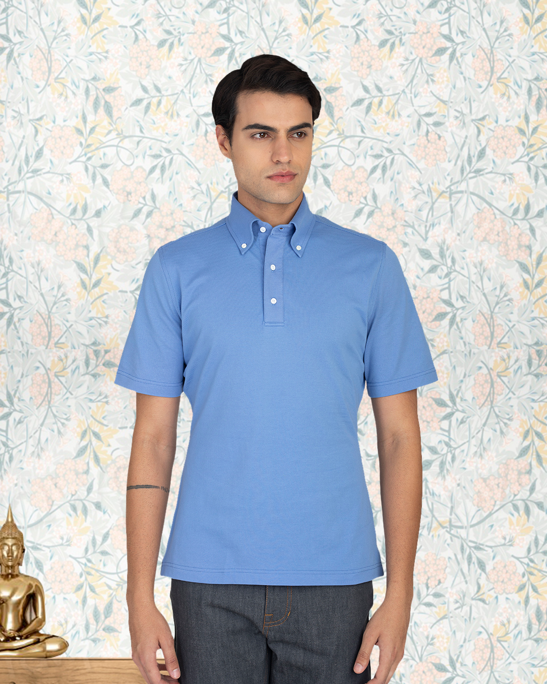 Close up view of model wearing the custom oxford polo shirt for men by Luxire in soft blue 3