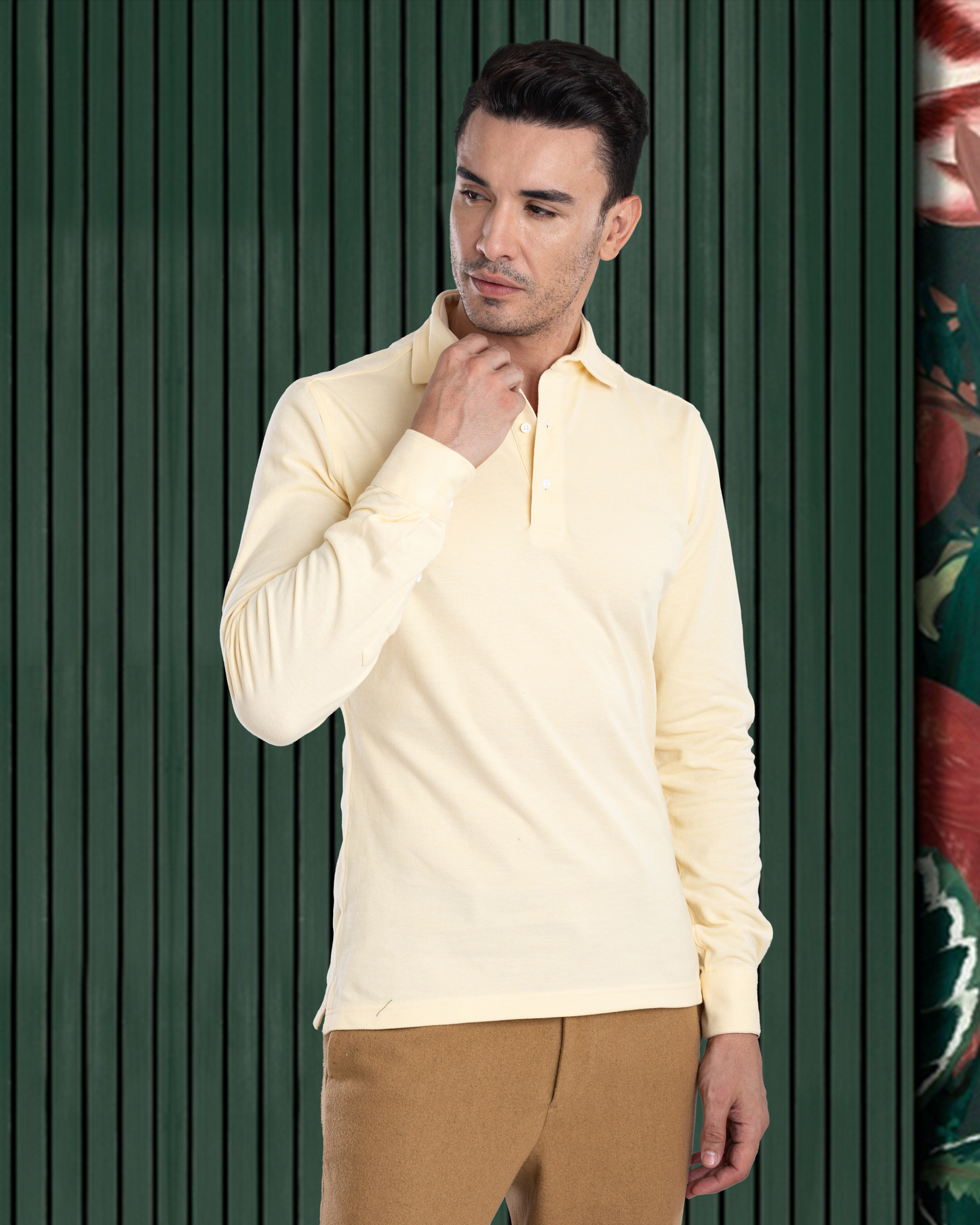 Model wearing the custom oxford polo shirt for men by Luxire in butter yellow hand on chin