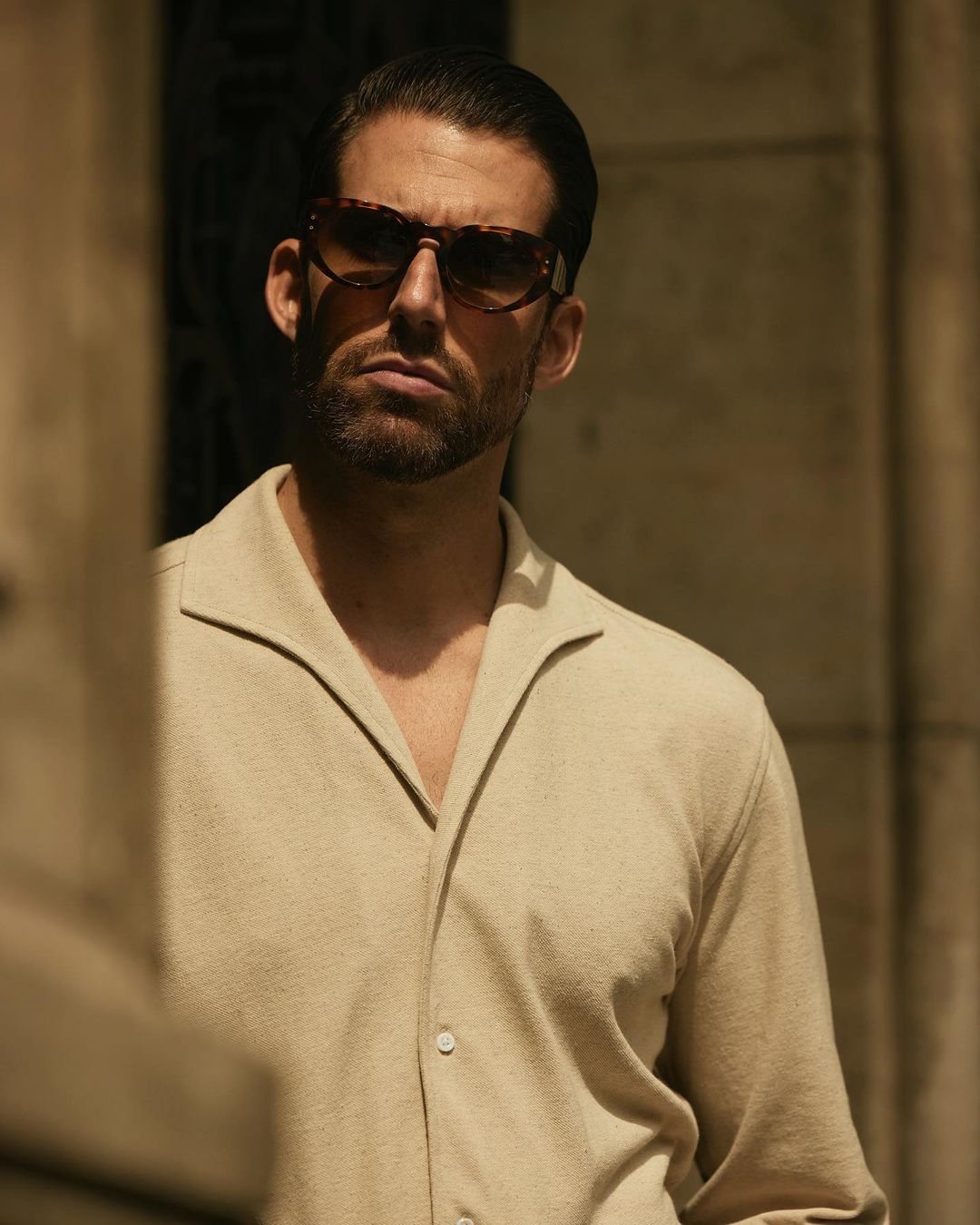 Close up of model wearing the custom oxford polo shirt for men by Luxire in heather cream 3
