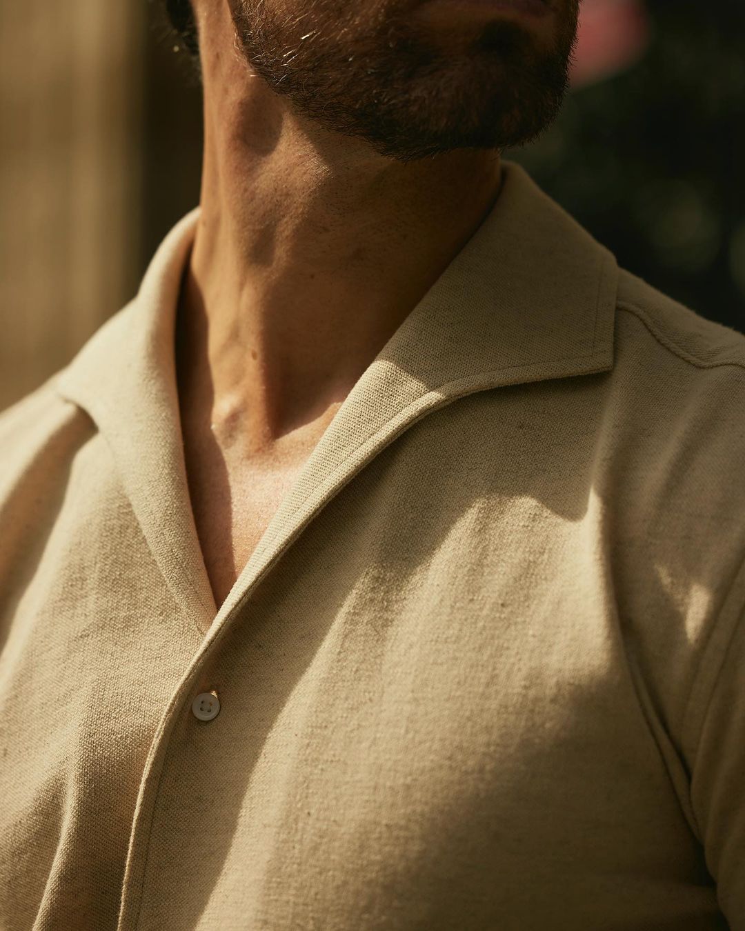 Close up of model wearing the custom oxford polo shirt for men by Luxire in heather cream 2