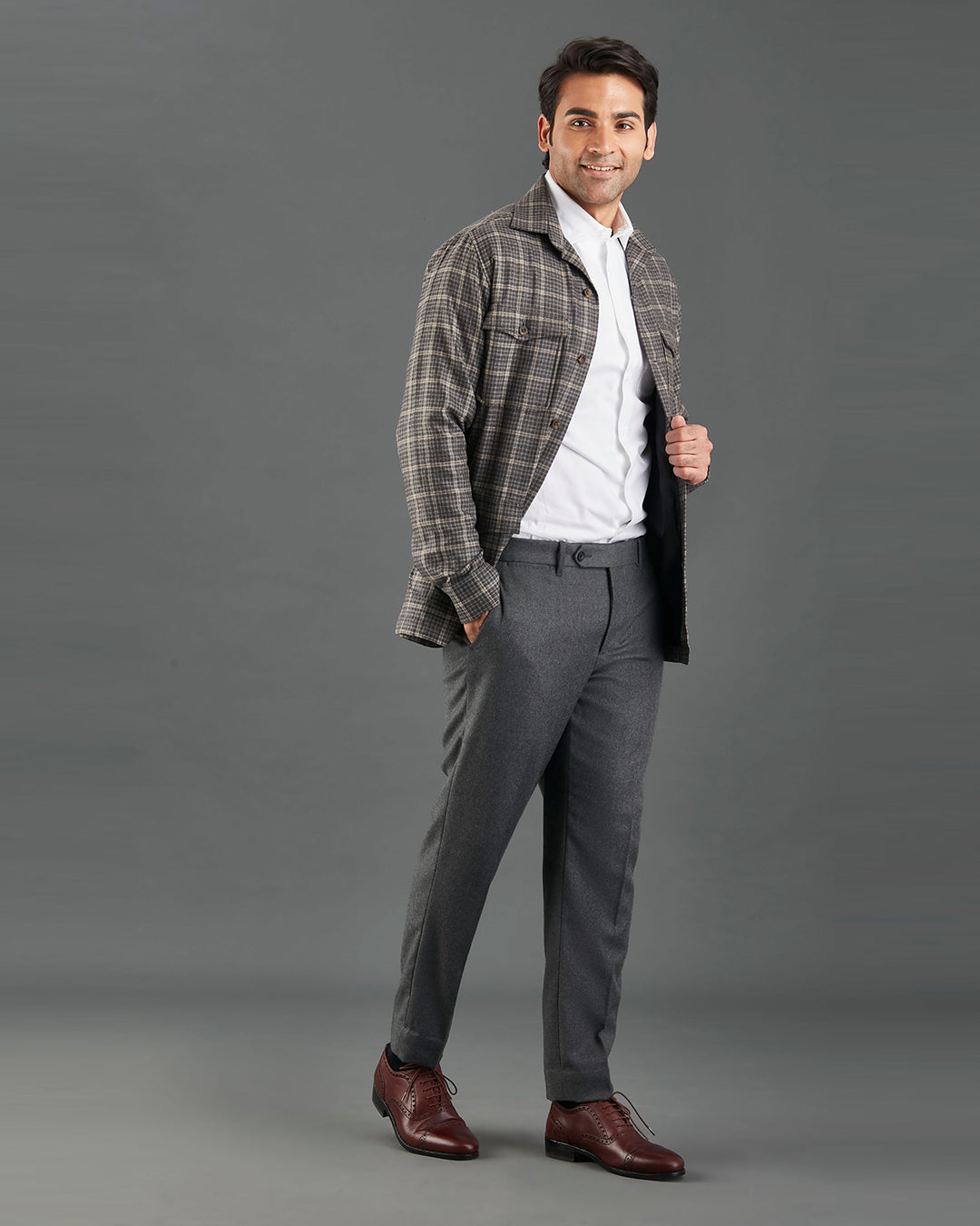 Side of model wearing the shirt jacket for men by Luxire in brown and grey overchecks