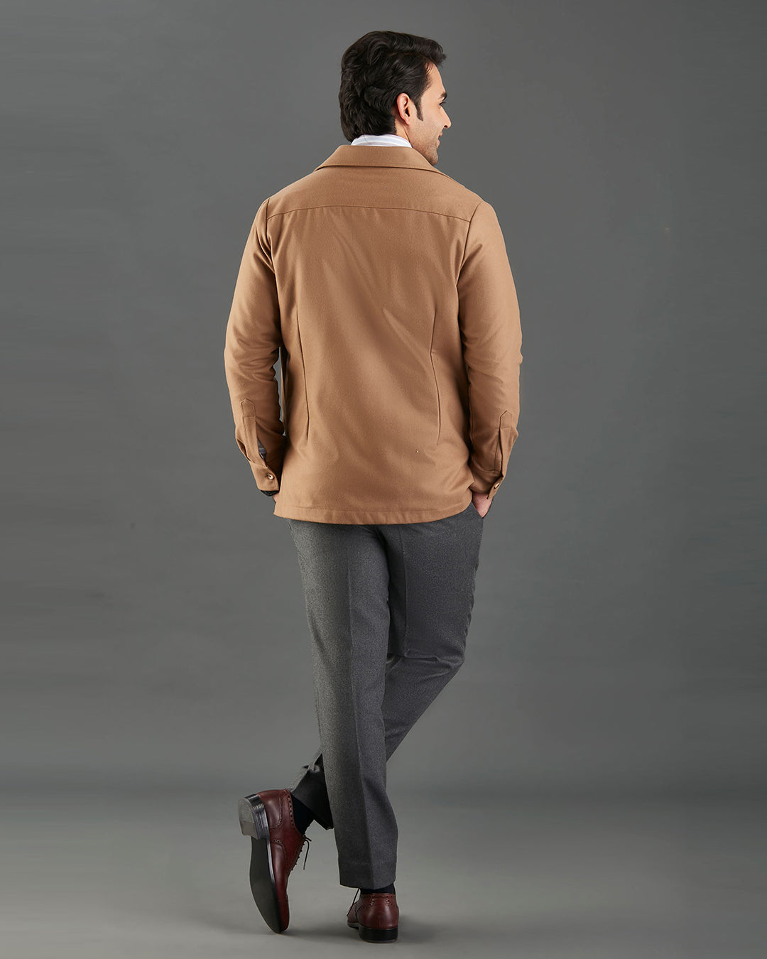 Back of model wearing the woolen flannel shirt jacket for men by Luxire in tan hands in pockets