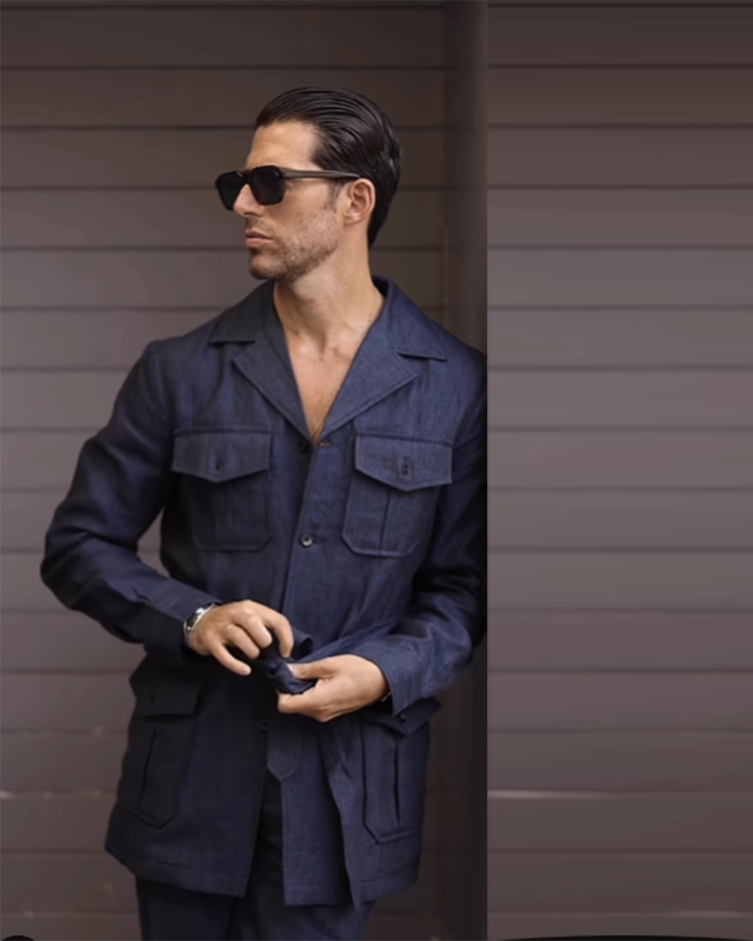 Model wearing the safari jacket in linen for men by Luxire in dark indigo hands together