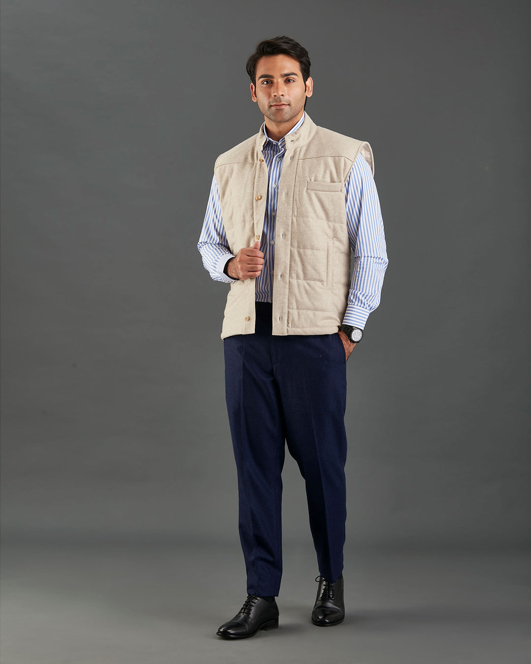 Front of model wearing the flannel quilted vest for men by Luxire in ecru hands in pockets