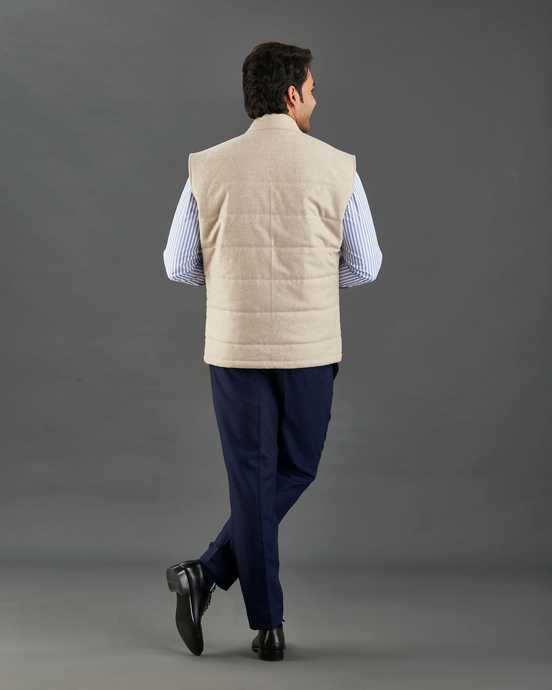 Back of model wearing the flannel quilted vest for men by Luxire in ecru hands in pockets hands in pockets