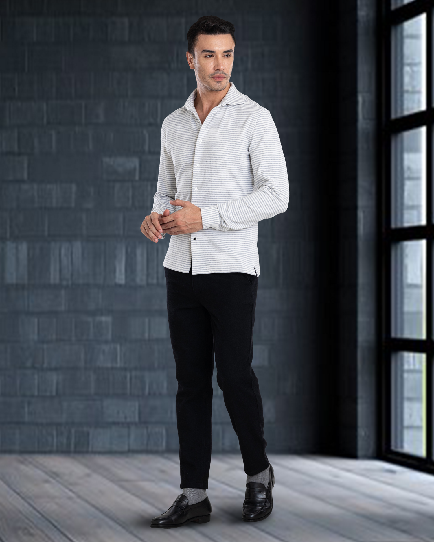 Model wearing custom wool Chino pants for men by Luxire in black hands together next to window