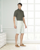 Model wearing custom Genoa shorts for men by Luxire in pale green wearing tan shoes