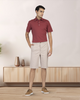 Model wearing custom Genoa shorts for men by Luxire in pale green wearing red top