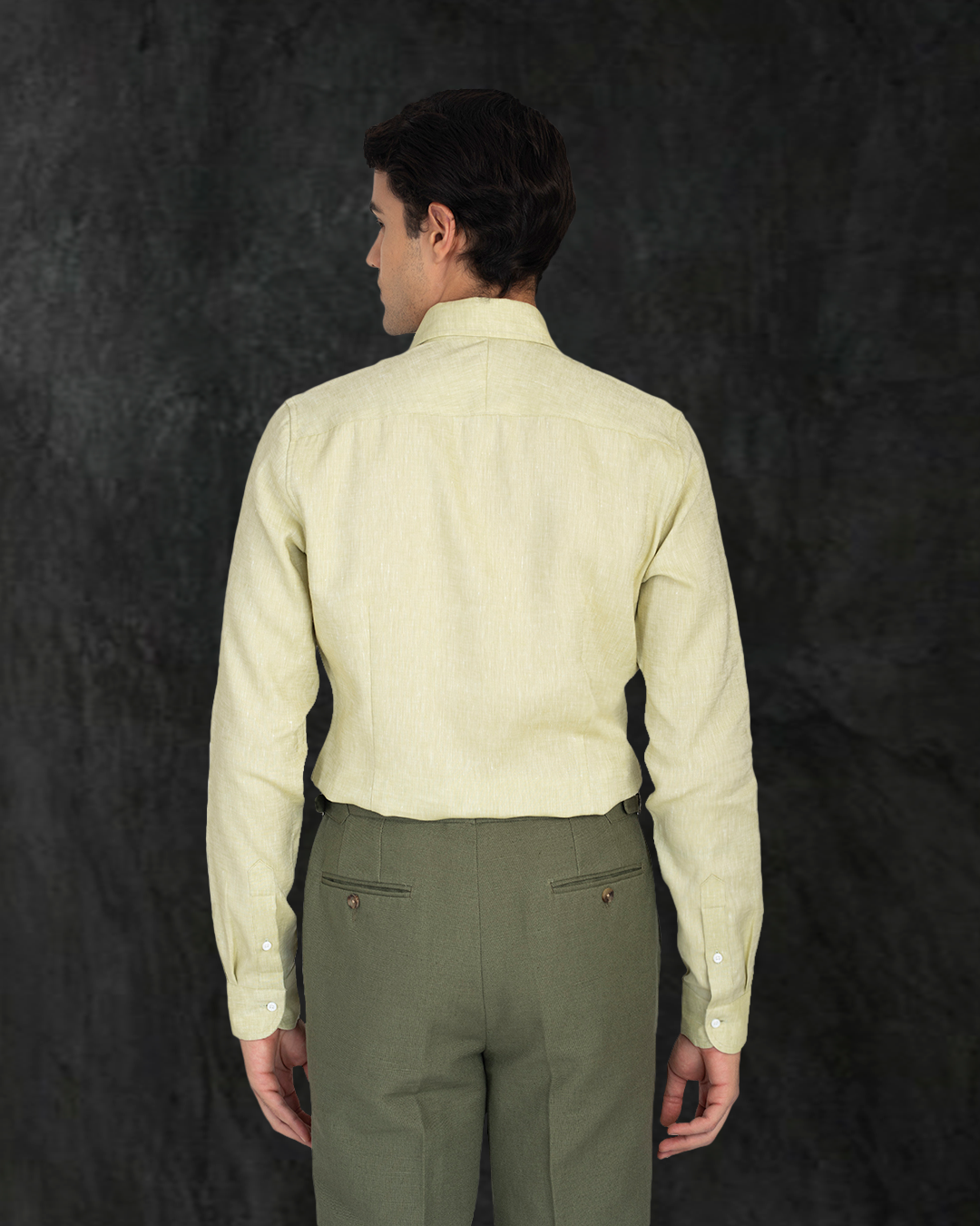 Male model back profile wearing custom linen canvas pants for men by Luxire in olive green