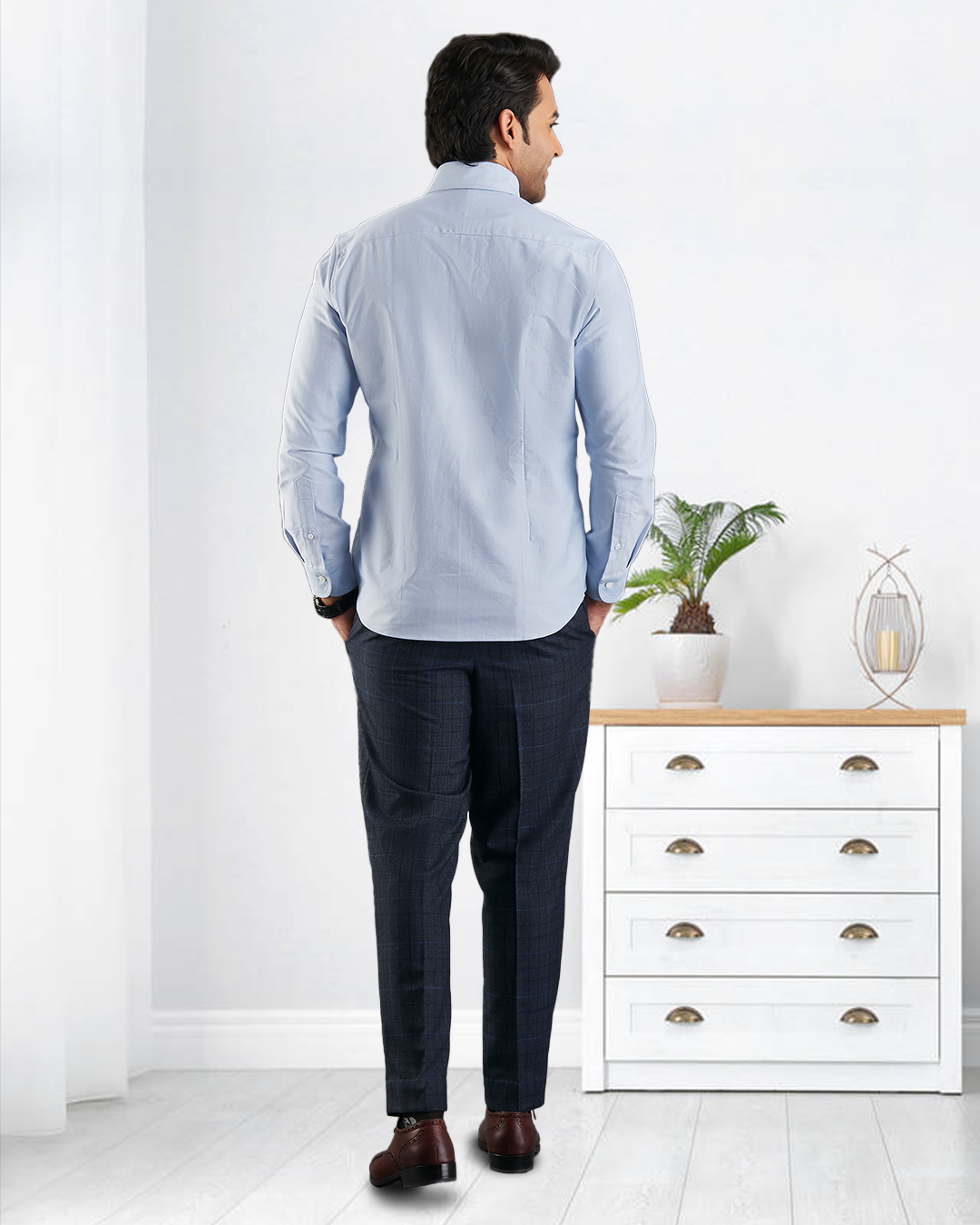 Back of model wearing the custom oxford shirt for men by Luxire in sky blue hands in pockets