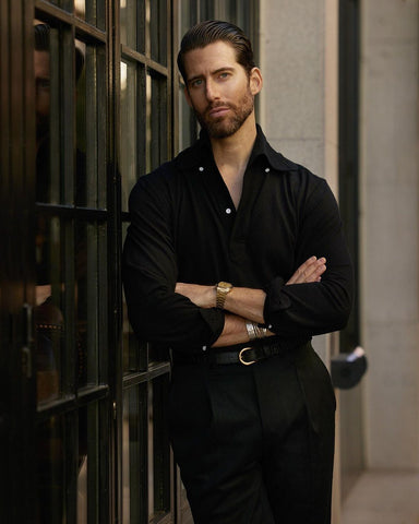 Model wearing the custom oxford polo shirt for men by Luxire in black pique arms crossed