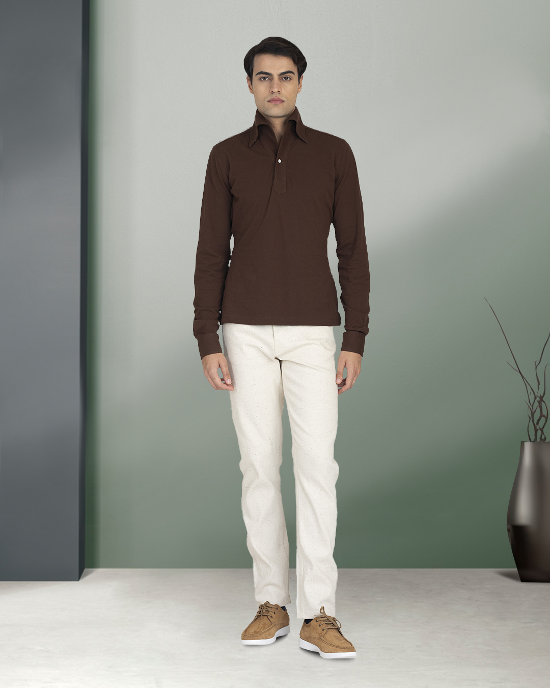Front of model wearing the custom oxford polo shirt for men by Luxire in brown pique hands at side