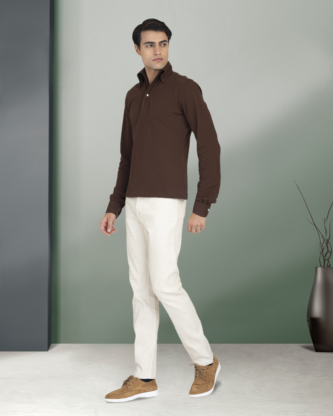 Front of model wearing the custom oxford polo shirt for men by Luxire in brown pique hands at side 2