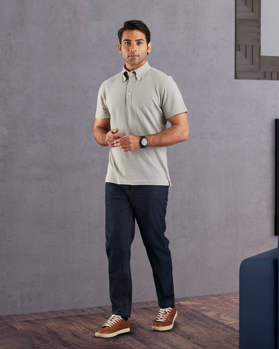 Model wearing the custom oxford polo shirt for men by Luxire in grey hands at waist 2