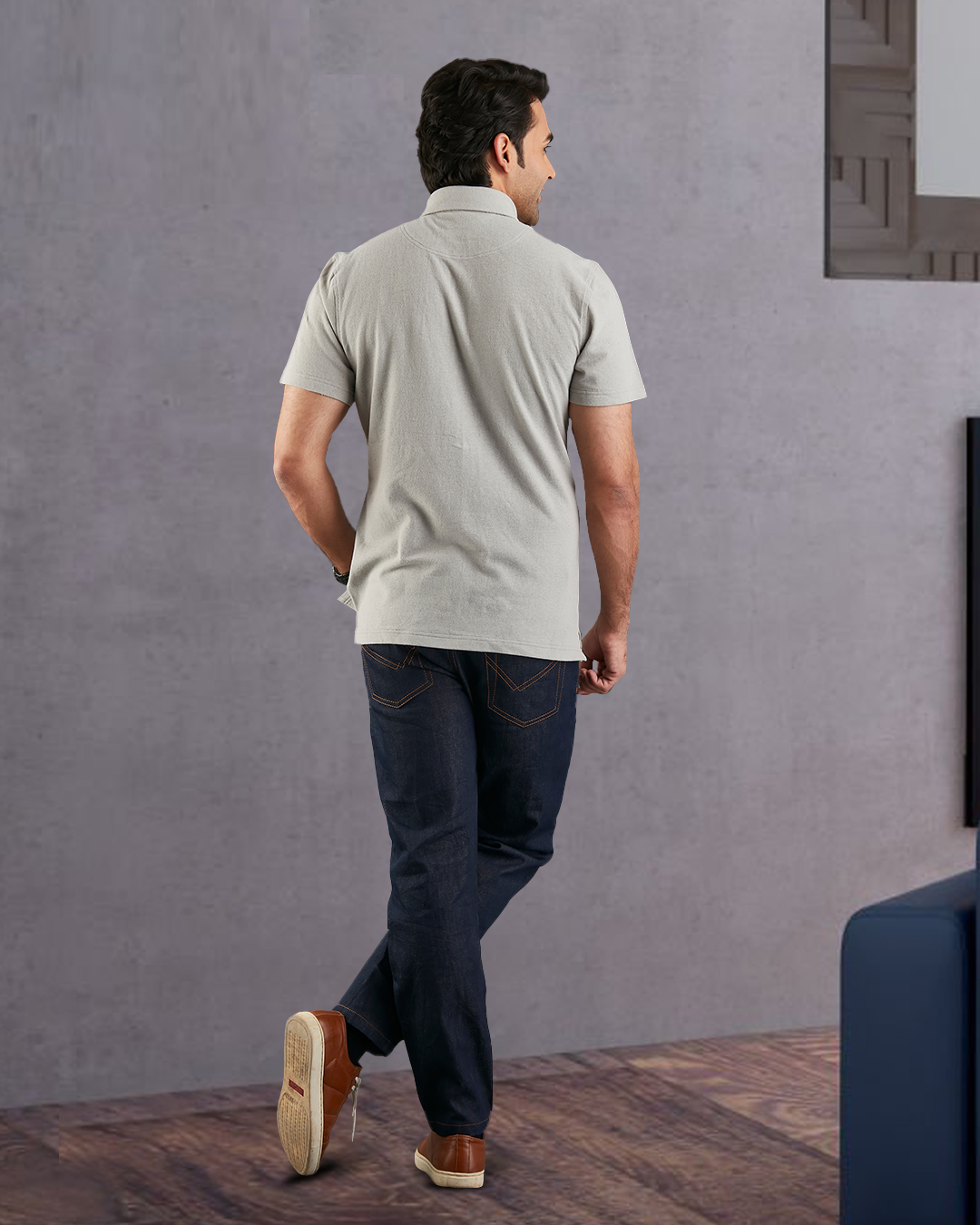 Back of model wearing the custom oxford polo shirt for men by Luxire in grey