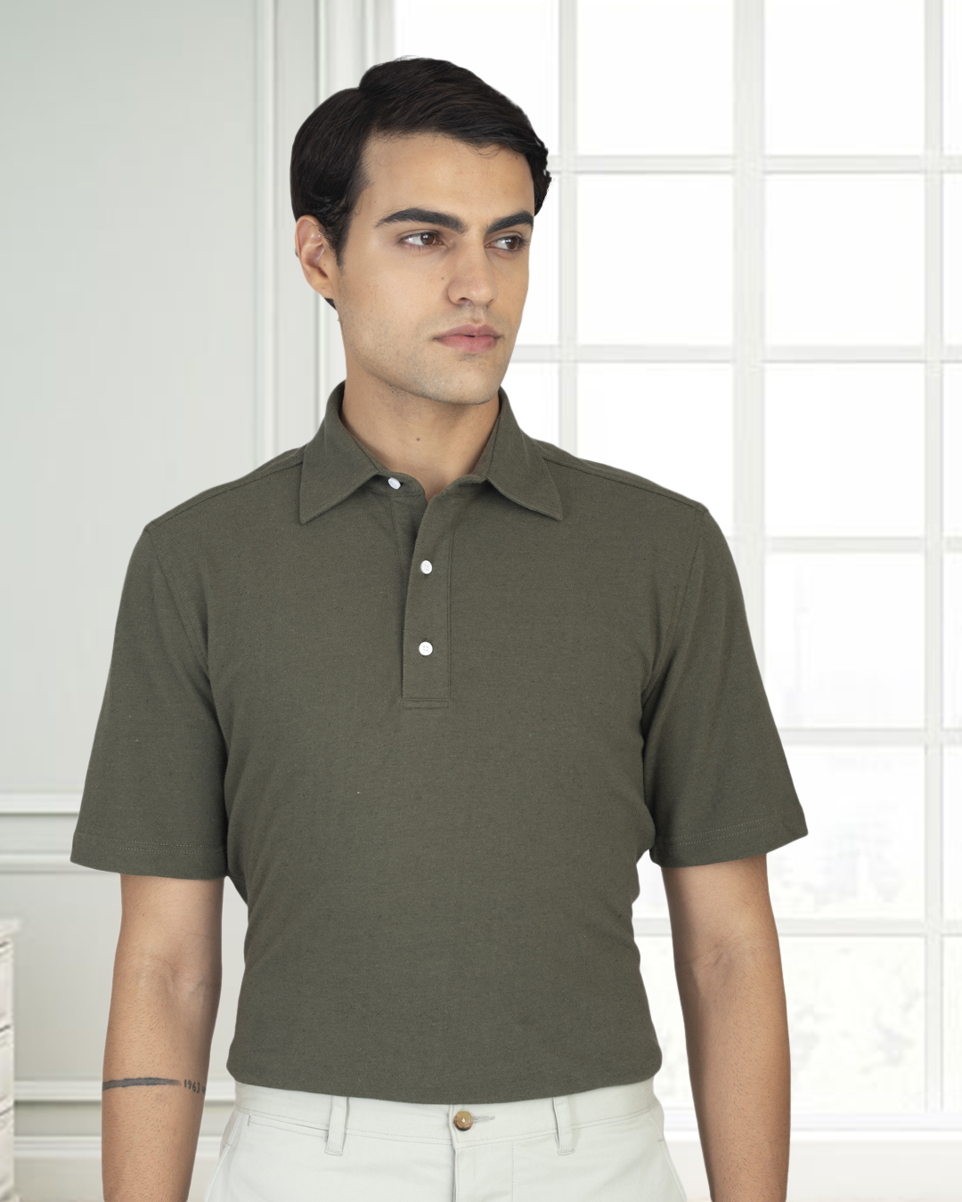 Front of model wearing the custom oxford polo shirt for men by Luxire in olive green