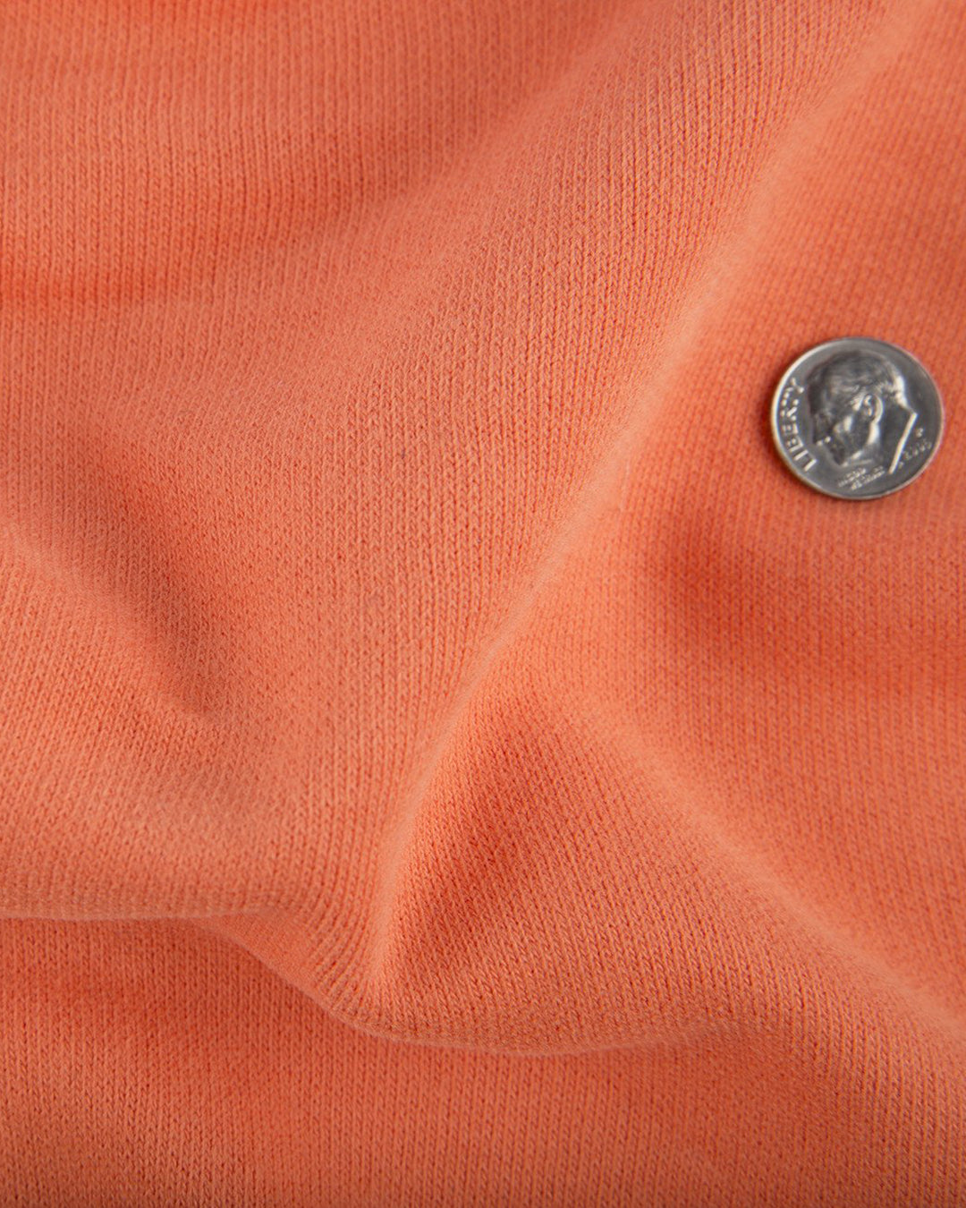 Close up of the custom oxford polo shirt for men by Luxire in bright orange