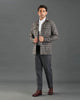 Front of model wearing the shirt jacket for men by Luxire in brown and grey overchecks hands together