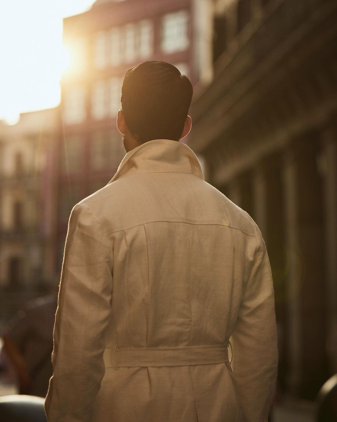 Back of model outside wearing the safari jacket in linen cotton for men by Luxire in off white